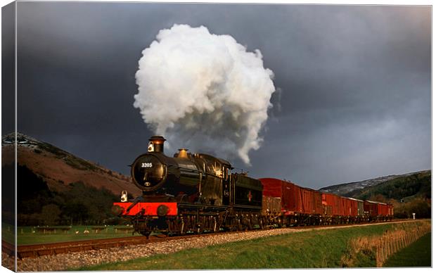  Goods train in the sun as a snowstorm approaches Canvas Print by Ian Duffield