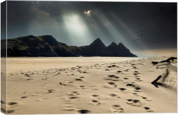 Shafts of light over Three Cliffs Bay Canvas Print by Leighton Collins