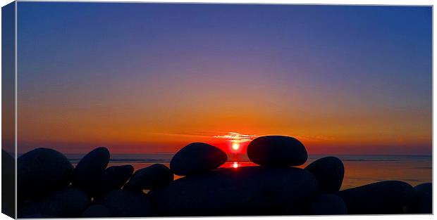 Sunset Through The Pebbles Canvas Print by Pete Moyes
