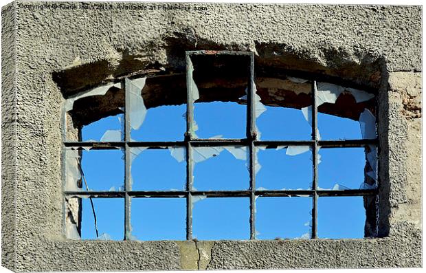 A smashed window showinga  clear blue sky behind. Canvas Print by Frank Irwin