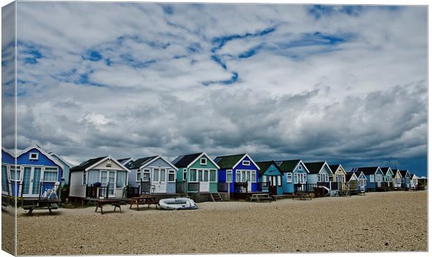 Stormy skys over beach huts Canvas Print by Dan Ward