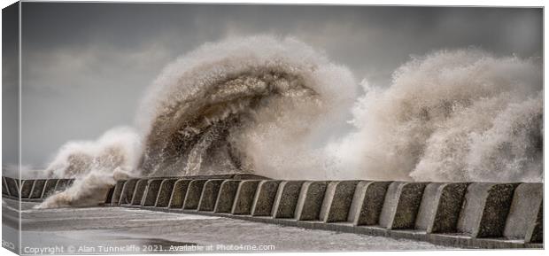 Large waves crashing over sea wall Canvas Print by Alan Tunnicliffe
