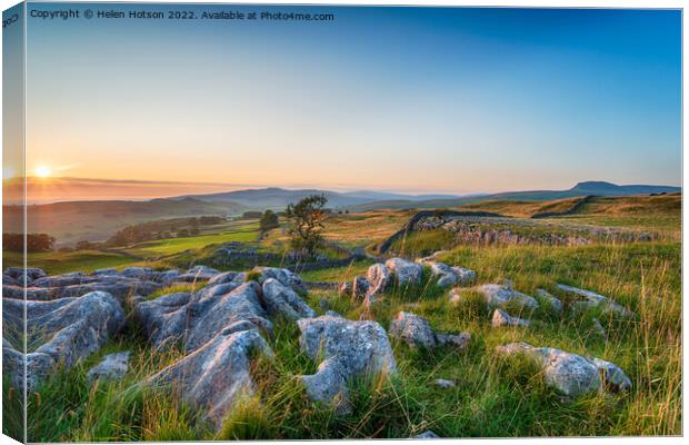 Sunset with clear blue skies over a limestone pavement at the Wi Canvas Print by Helen Hotson