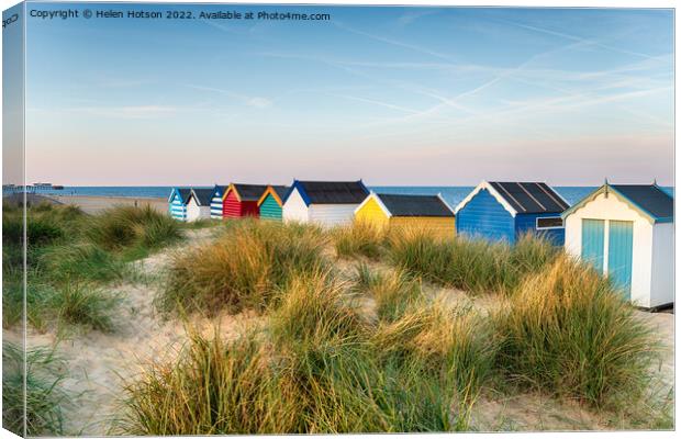 Beach huts in the sand dunes at Southwold  Canvas Print by Helen Hotson