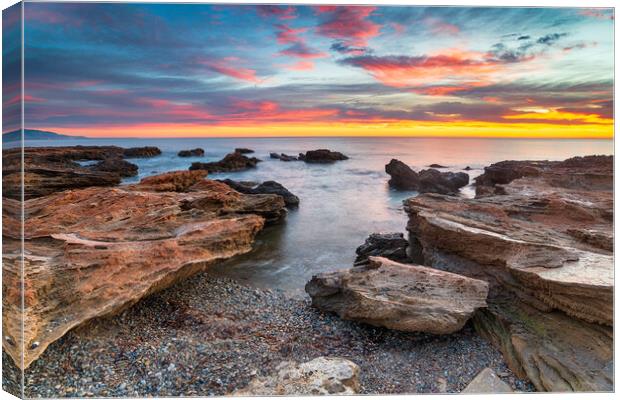 Stunning sunrise over the beach and rocks at Torre de la Sal  Canvas Print by Helen Hotson