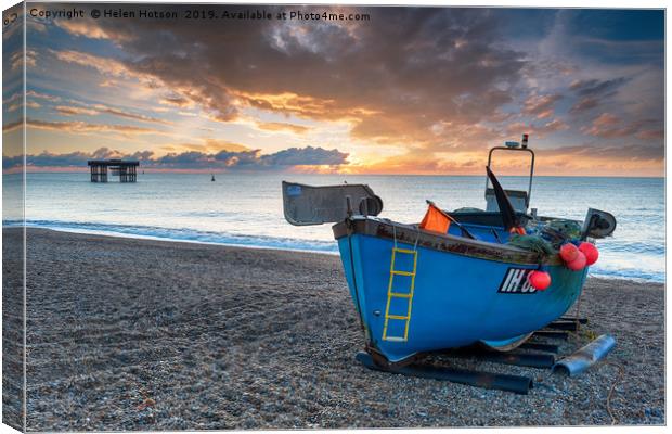 Dramatic sunrise sky over a fishing boat on the be Canvas Print by Helen Hotson