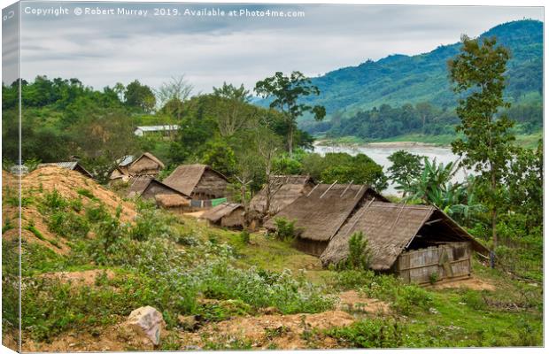 Tribal Village on the Mekong, Laos. Canvas Print by Robert Murray