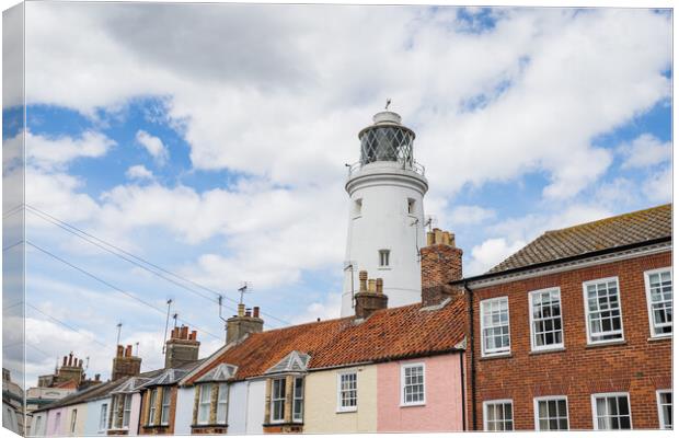 Southwold Lighthouse behind colourful houses Canvas Print by Jason Wells