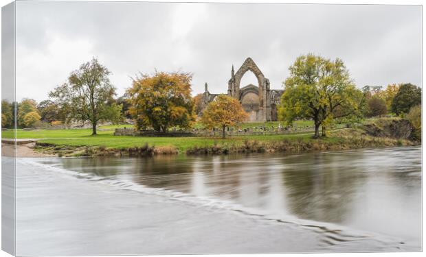 Bolton Abbey over submerged stepping stones Canvas Print by Jason Wells