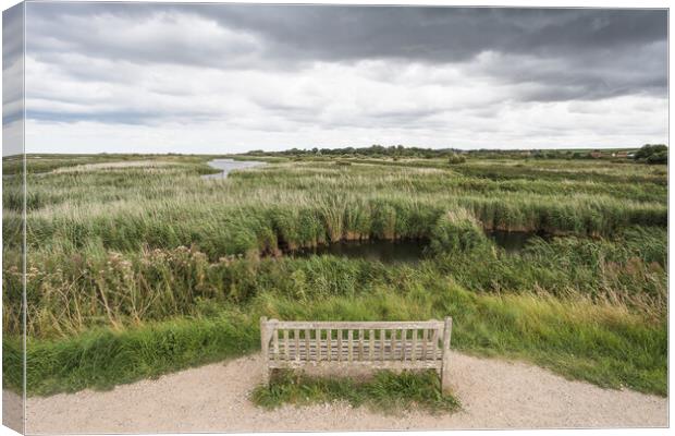 Lone bench overlooking the Titchwell nature reserve Canvas Print by Jason Wells