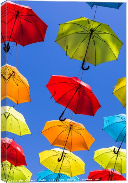Suspended umbrellas swaying in the wind Canvas Print by Jason Wells