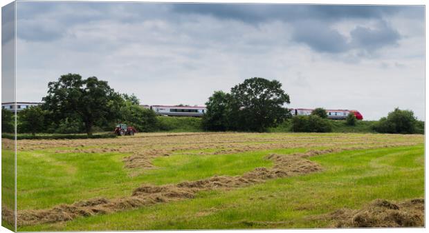 A Virgin train passes a tractor on a field Canvas Print by Jason Wells