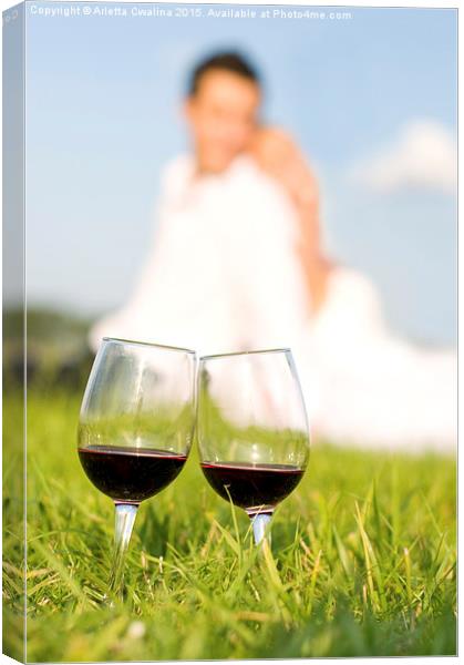 two wineglasses with red wine in grass  Canvas Print by Arletta Cwalina