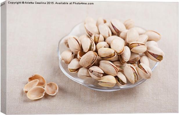 pistachio nuts in shell lying on glass plate  Canvas Print by Arletta Cwalina