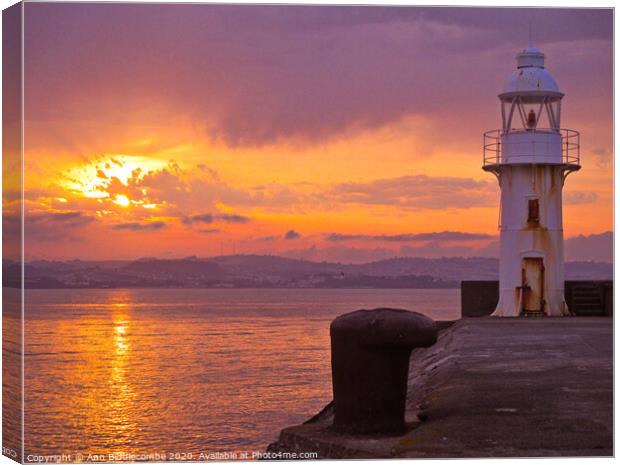 Sunset over Brixham Lighthouse Canvas Print by Ann Biddlecombe
