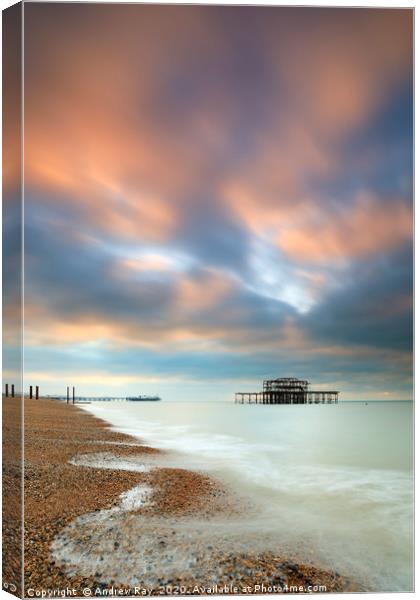 Brighton Piers at sunrise Canvas Print by Andrew Ray