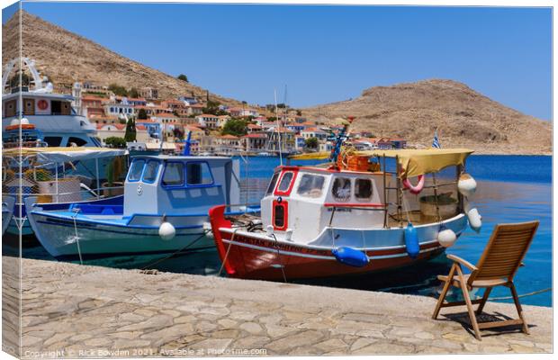 Halki Boats and Chair Canvas Print by Rick Bowden