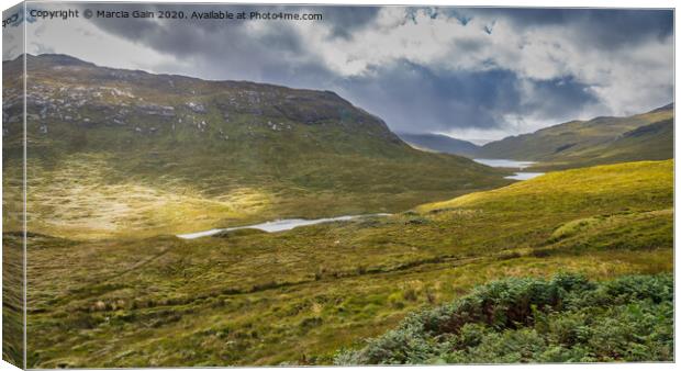 A lush green hillside with three lochs in the back Canvas Print by Marcia Reay