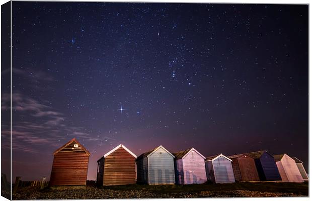 Orion over beach huts Canvas Print by Chris Nesbit