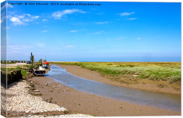 Low tide at Thornham Staithe  Canvas Print by John Edwards