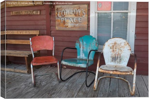 Coloured chairs on a cowboy veranda Canvas Print by Adrian Beese