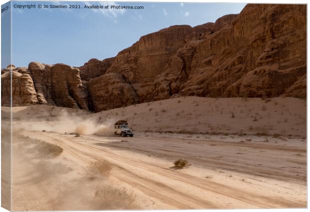 Jeep speeding through Wadi Rum, Jordan Canvas Print by Jo Sowden