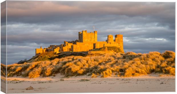 Sun setting on Iconic Bamburgh Castle Canvas Print by Naylor's Photography