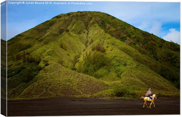 Bromo volcano and a lone horseman, Bromo, Indonesi Canvas Print by Julian Bound