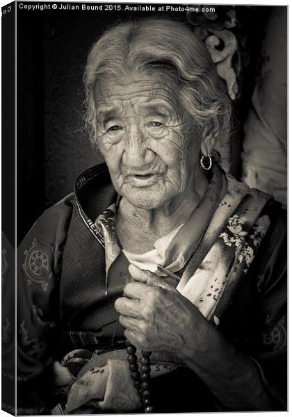 Elderly Tibetan lady, Boudhanath Temple, Kathmandu Canvas Print by Julian Bound