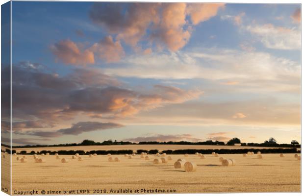 Norfolk hay bales basking in the sunset glow Canvas Print by Simon Bratt LRPS
