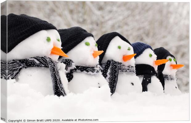 Snowmen close up in a row Canvas Print by Simon Bratt LRPS