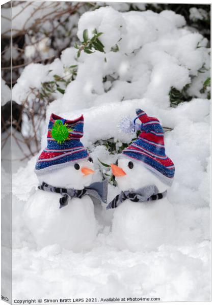 Two cute little snowmen dressed for snow Canvas Print by Simon Bratt LRPS