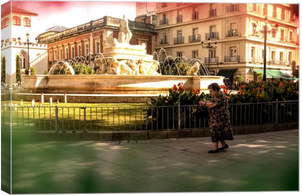 An old lady is walking in front of a fountain Canvas Print by Jose Manuel Espigares Garc