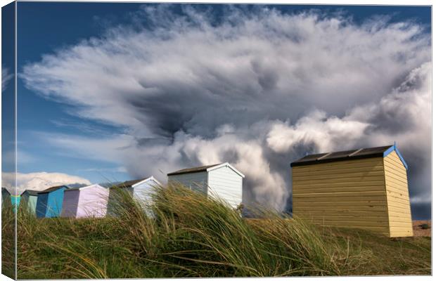 Kent Beach Huts with storm clouds Canvas Print by John Finney