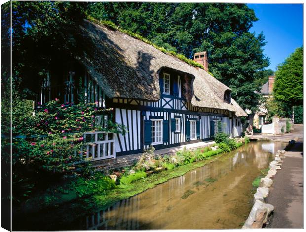   Half timber frame house with stream Normandy Fra Canvas Print by Philip Enticknap