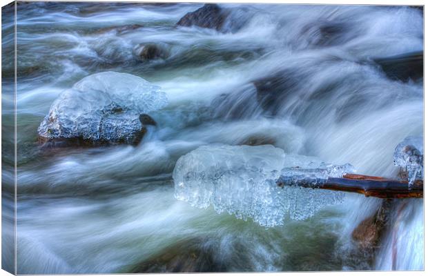 Icicles on rocks over river Canvas Print by S Fierros