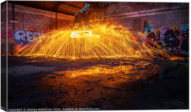 Showers of hot glowing sparks from spinning steel  Canvas Print by George Robertson
