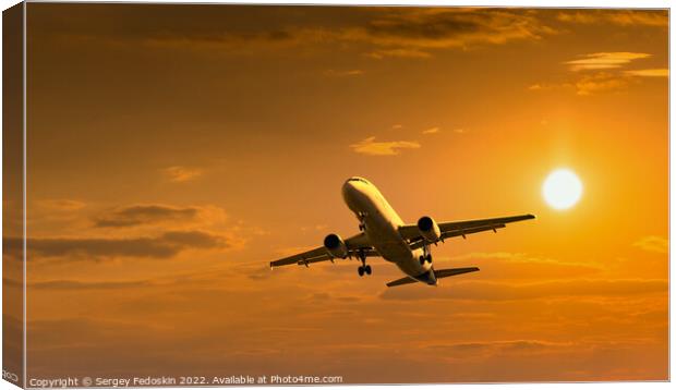 Passenger commercial aircraft flying under the clouds in sunset light. Canvas Print by Sergey Fedoskin