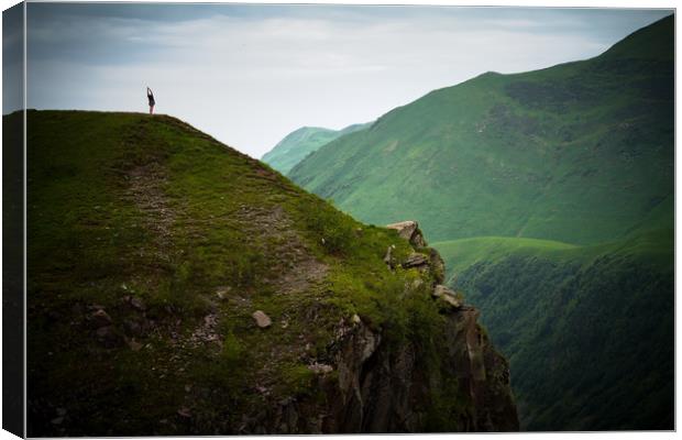 Yoga in the dark sombre mountains. Canvas Print by Tartalja 