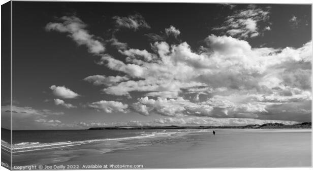 A lone beach walker under a dramatic sky Canvas Print by Joe Dailly