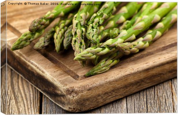 Fresh Asparagus on rustic wooden server board Canvas Print by Thomas Baker