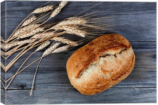 Close up view of homemade sourdough bread with dried wheat stalk Canvas Print by Thomas Baker