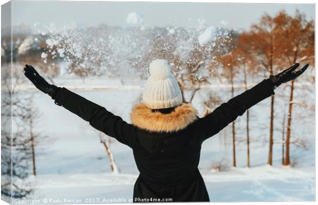 Happy Girl Throwing Snow In Air During Winter Canvas Print by Radu Bercan