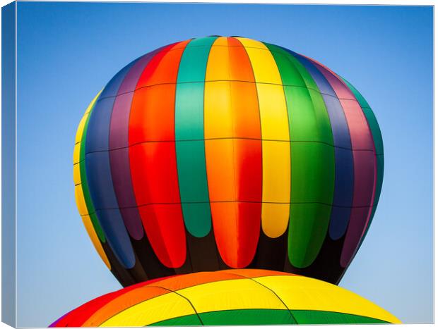 Colorful hot air balloon rising above another with Canvas Print by Steve Heap