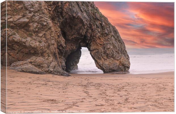 Beautiful stone natural arche. Rock formation in a beach with ocean in background at the sunset Canvas Print by nuno valadas