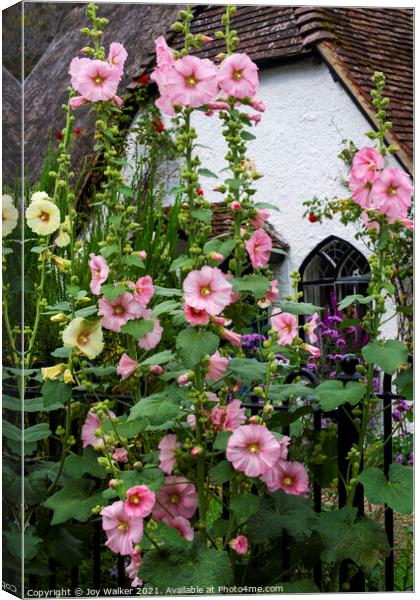 A thatched cottage with Hollyhock flowers  Canvas Print by Joy Walker