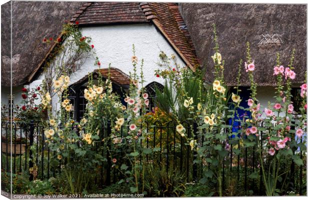 A thatched cottage with Hollyhock flowers Canvas Print by Joy Walker