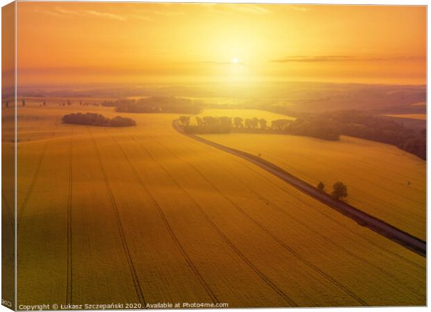 Aerial view of yellow canola field and country roa Canvas Print by Łukasz Szczepański