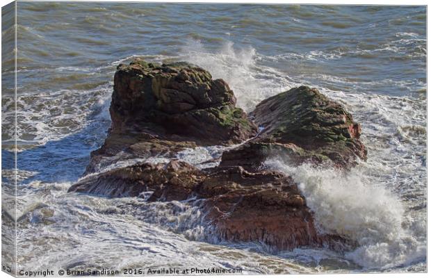 A Heavy Sea smashes the exposed rocks Canvas Print by Brian Sandison