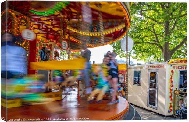 Fairground carousel ride blurred to show speed and movement with small child watching, London UK Canvas Print by Dave Collins